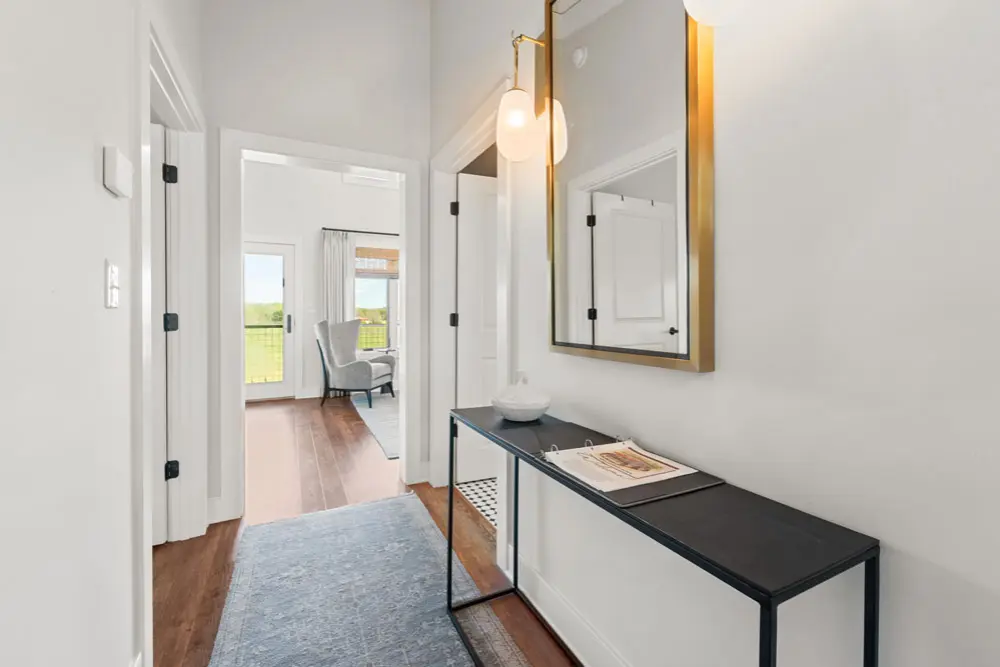Hallway interior with console table, mirror, and view of a living room.