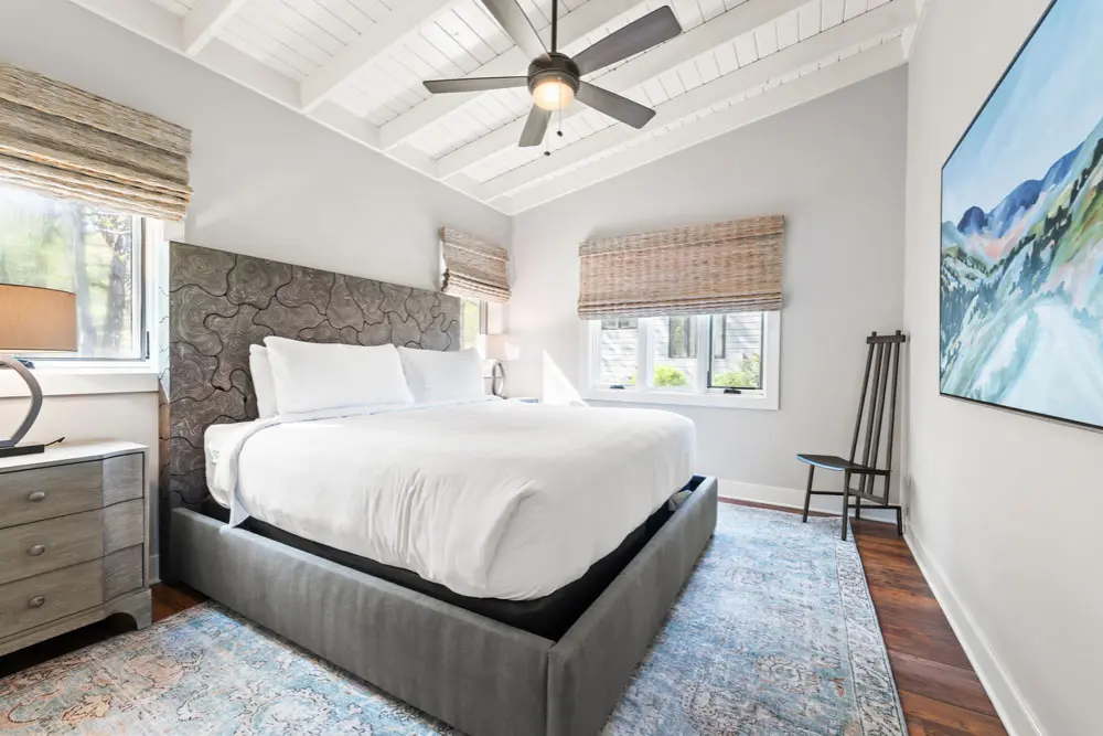 Bedroom with white walls and wooden floors.