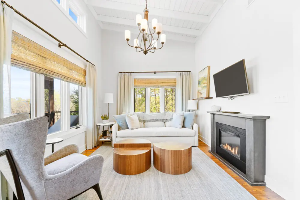 Living room with white sofa, fireplace, and wood coffee tables.