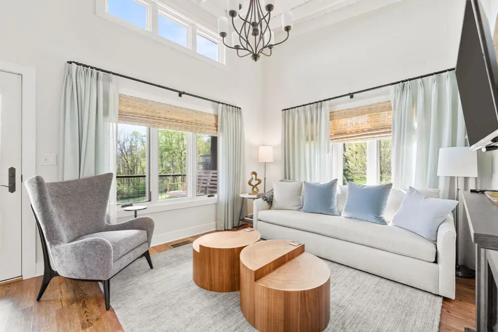 Living room with light-colored sofa, armchair, and wooden coffee tables.