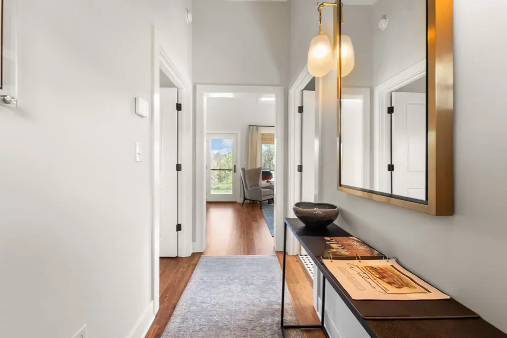 Hallway with hardwood floors, a console table, and a large mirror.