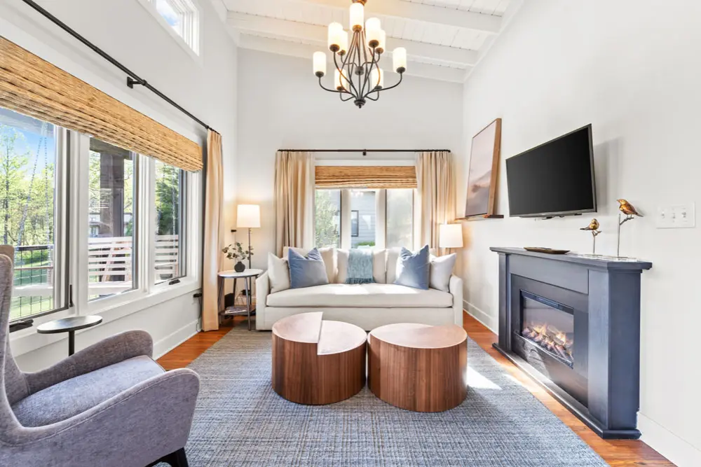 Living room with white couch, fireplace, and wood coffee tables.
