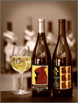 Two bottle of wine and a glass.