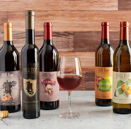 Hill top wines with a glass in the middle.