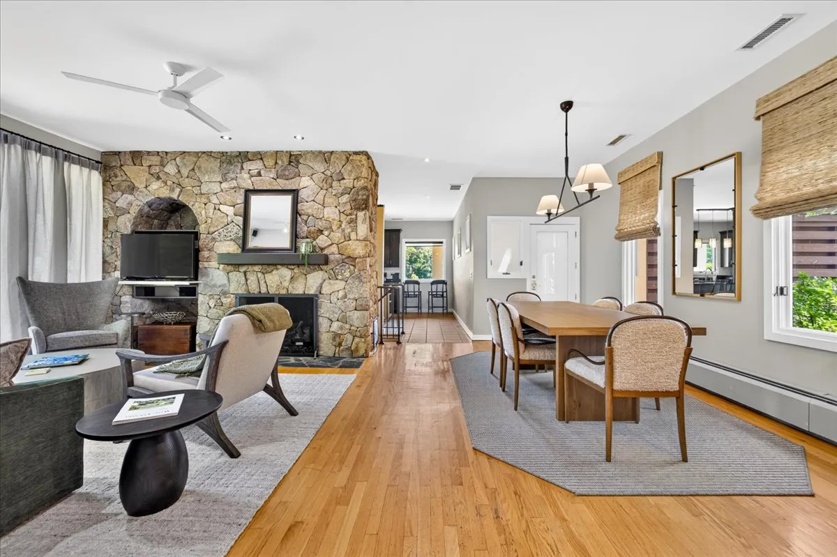 Open-concept living and dining area with stone fireplace.