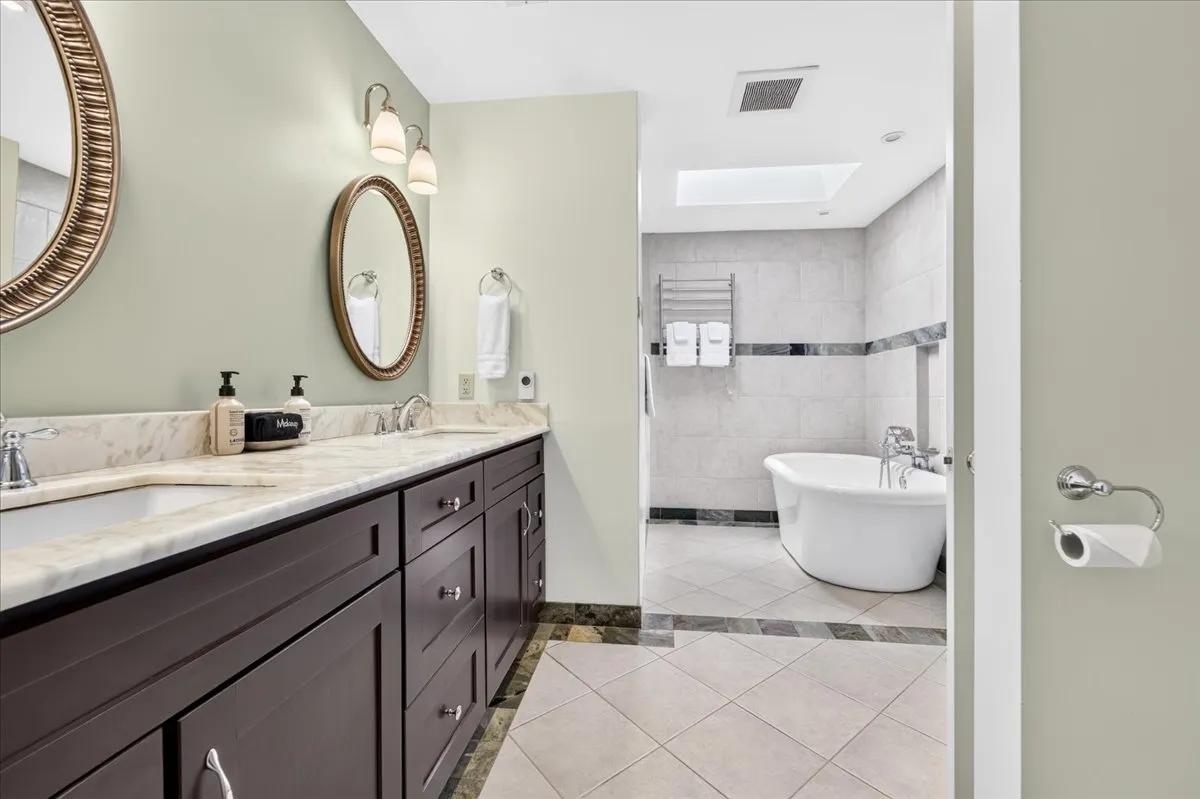 Luxury bathroom with double vanity and freestanding soaking tub.